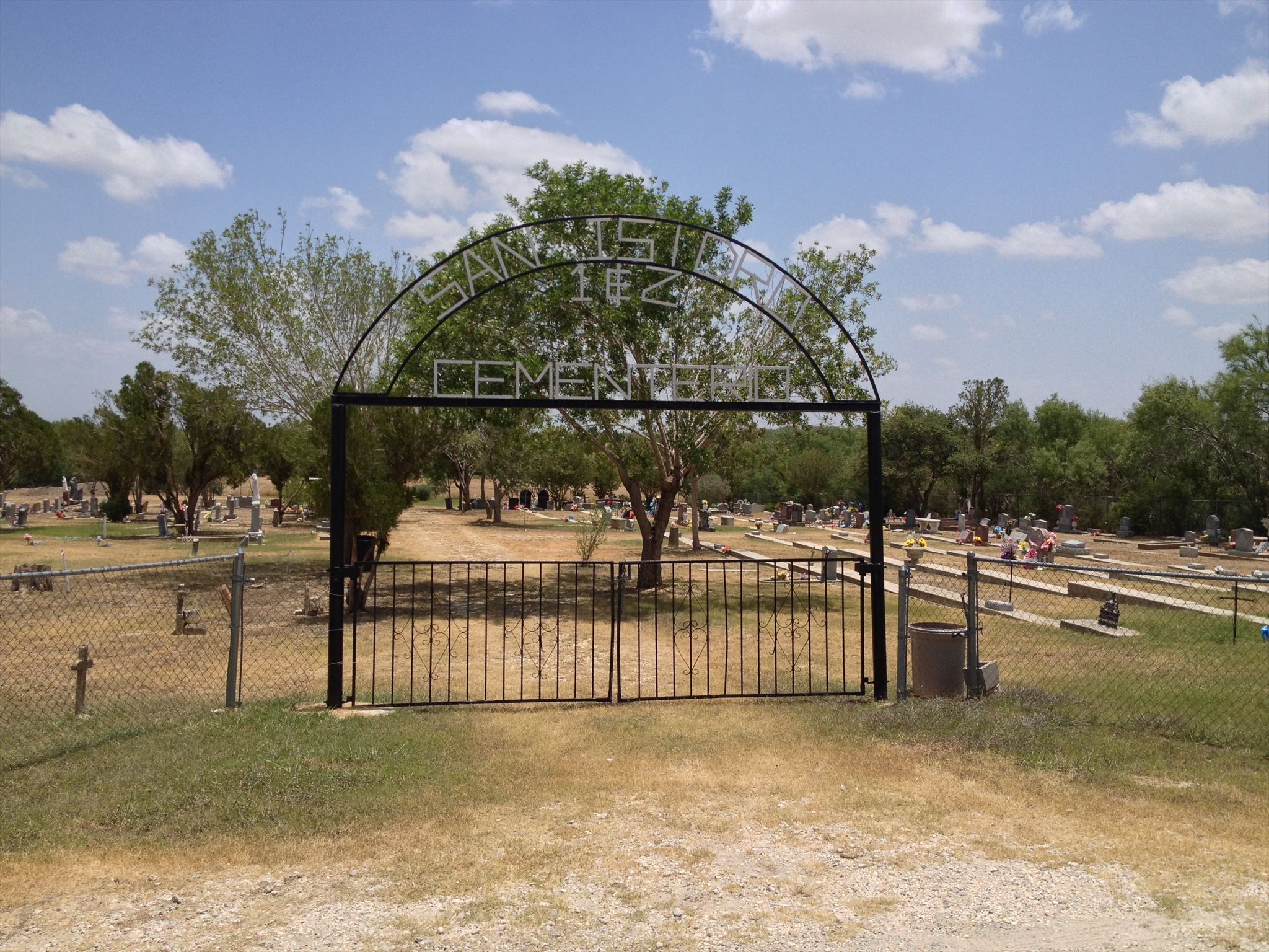 front gates of a cemetery with an arching sign that reads San Isidro Cemetery 1&2