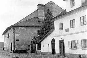 Loštice kolem r. 1930. Tmavá budova na pozadí je synagoga a k ní přilehlé dvoupodlažní křídlo, kde byly byty pro rabína a jeho asistenta.