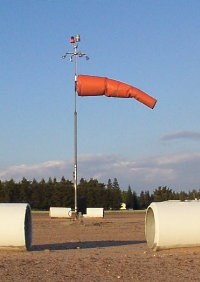 Count the white, concrete pipes around this windsock.